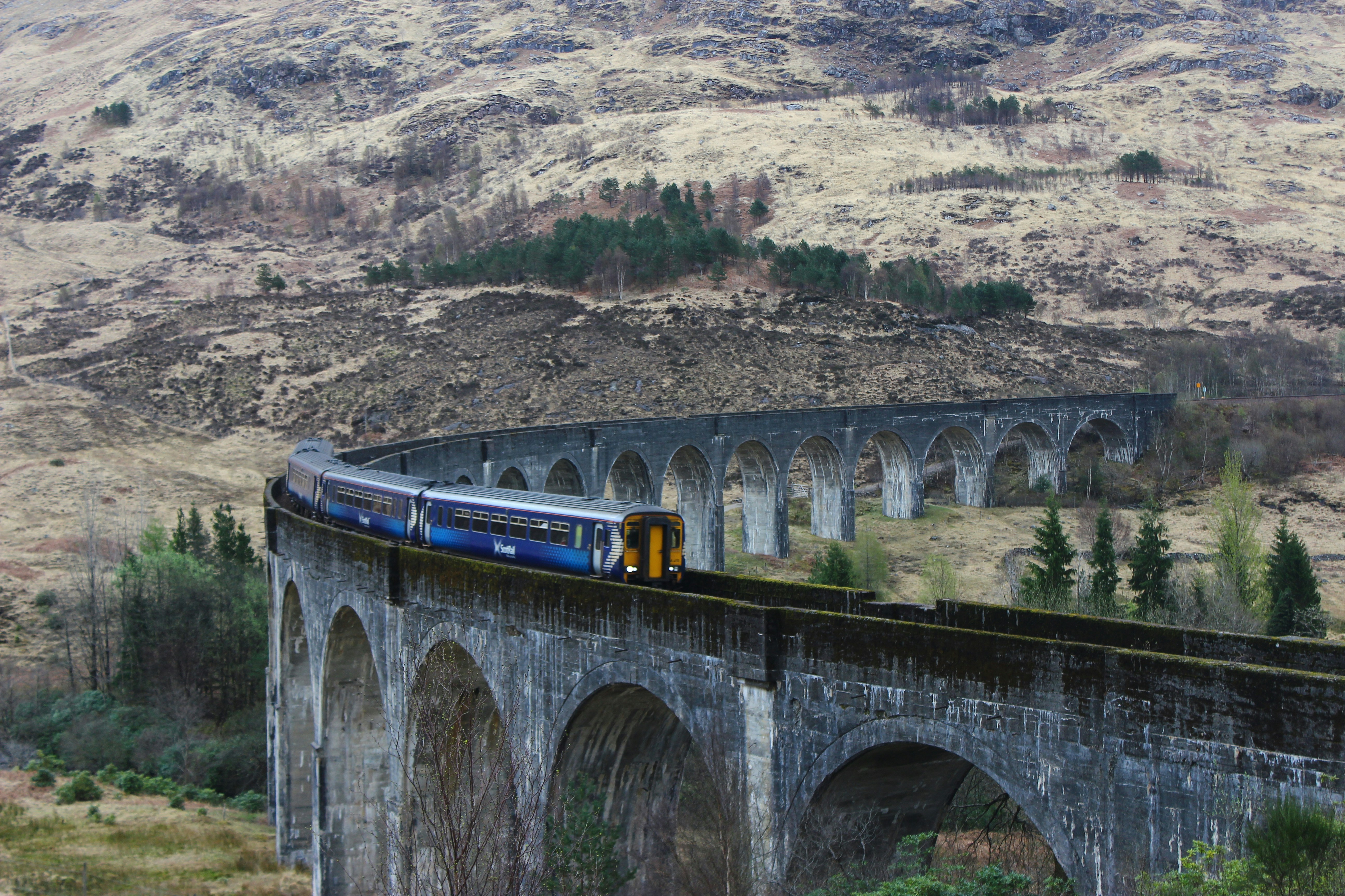 A ScotRail train crossing Glenfinnan Viaduct in the Scottish Highlands